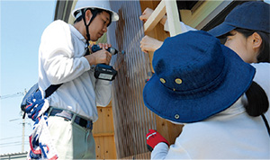写真：仮設住宅の風除壁設置作業